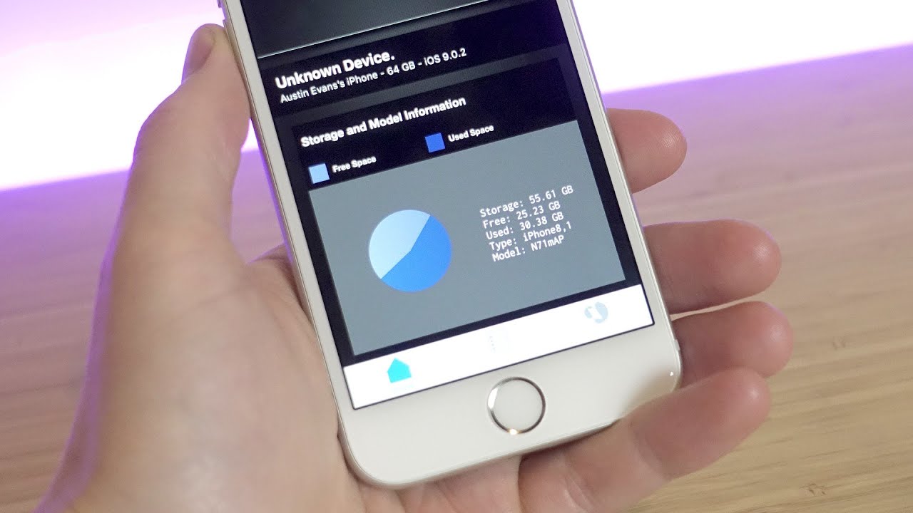 Austin Evans holding an iPhone running Lirum Device Info, showing storage and model details.